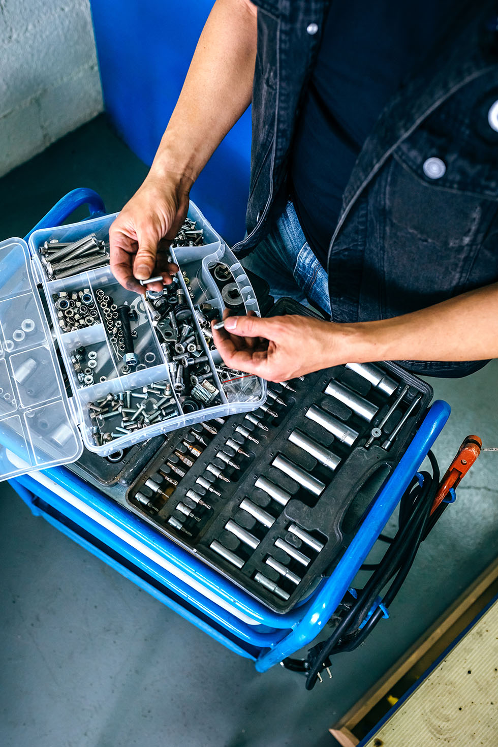 Mechanic’s hands choosing screws from a tool box